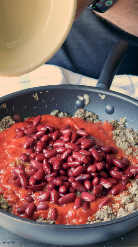 When the beef is fully cooked, add tomato paste, tomato sauce, and kidney beans, and let it simmer. 